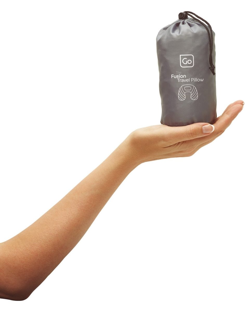 Close up view of hand holding Go Travel The Fusion Travel Pillow in carry pouch.