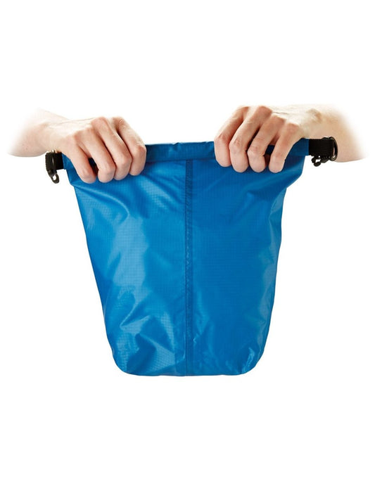 Product Image – Front view of blue Go Travel Wet/Dry Bag, with hands rolling up the top to seal contents inside.