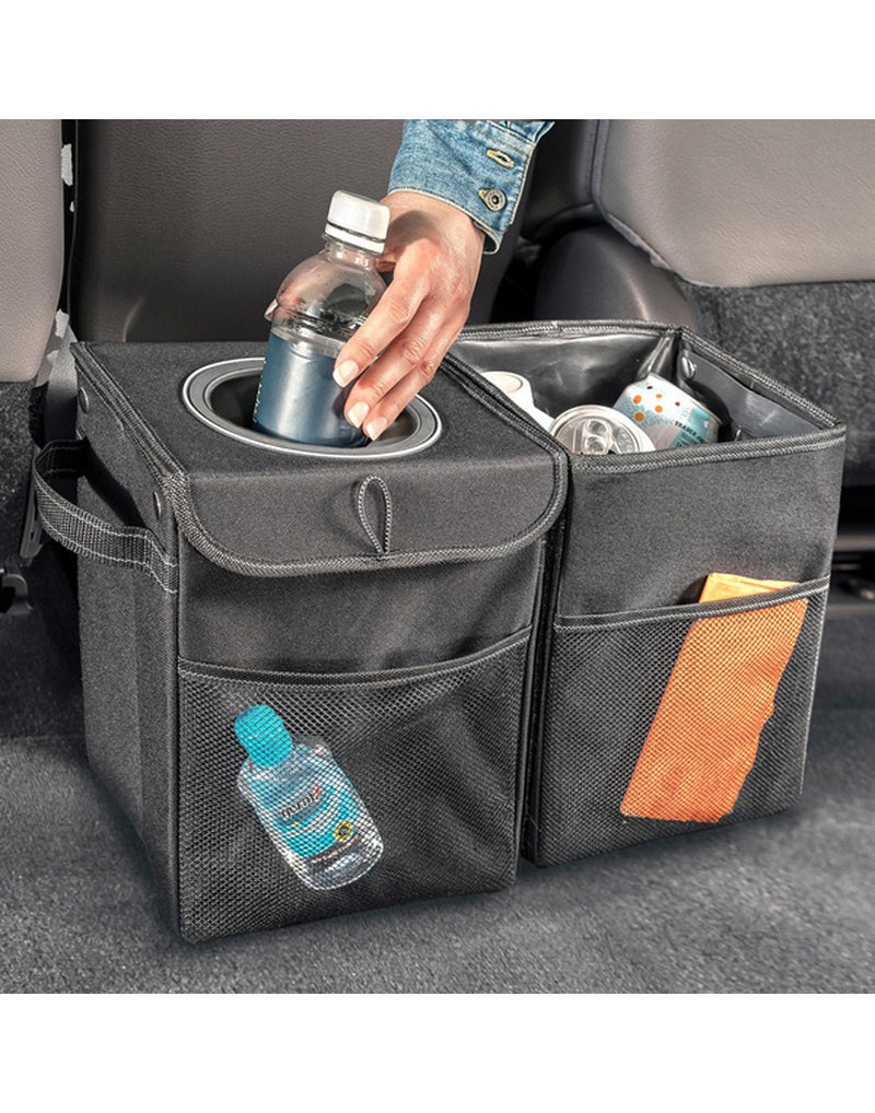 Lifestyle image of hand throwing out garbage in High Road® StashAway® Car Recycling Bin, with other items also positioned inside.