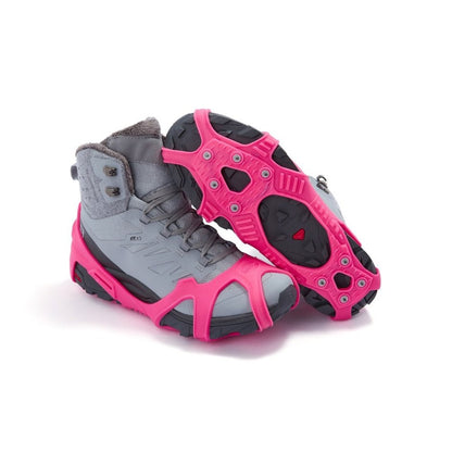 Icetrax V3 Tungsten Ice Cleats in bright pink on a pair of grey hiking boots, side view, one boot is upturned to show bottom cleats