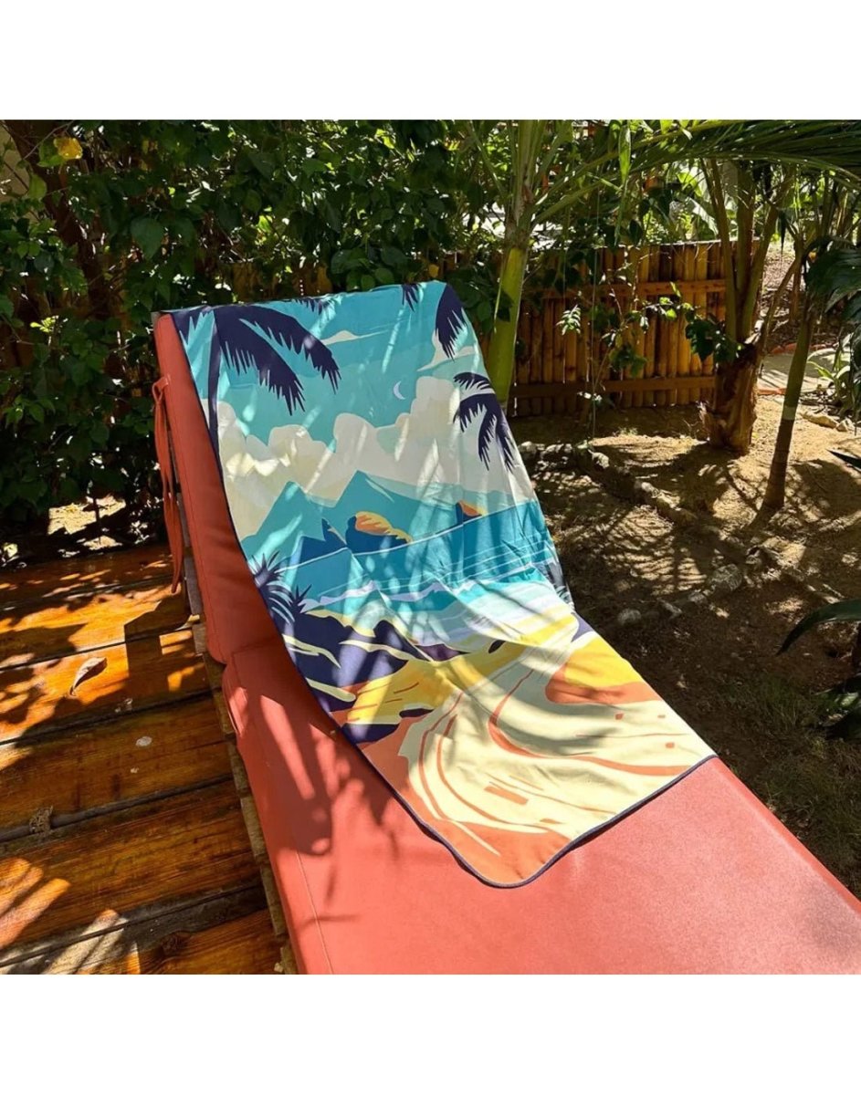 Lifestyle image of paradise island K5 Microfibre Beach Towel, placed on a poolside chair.