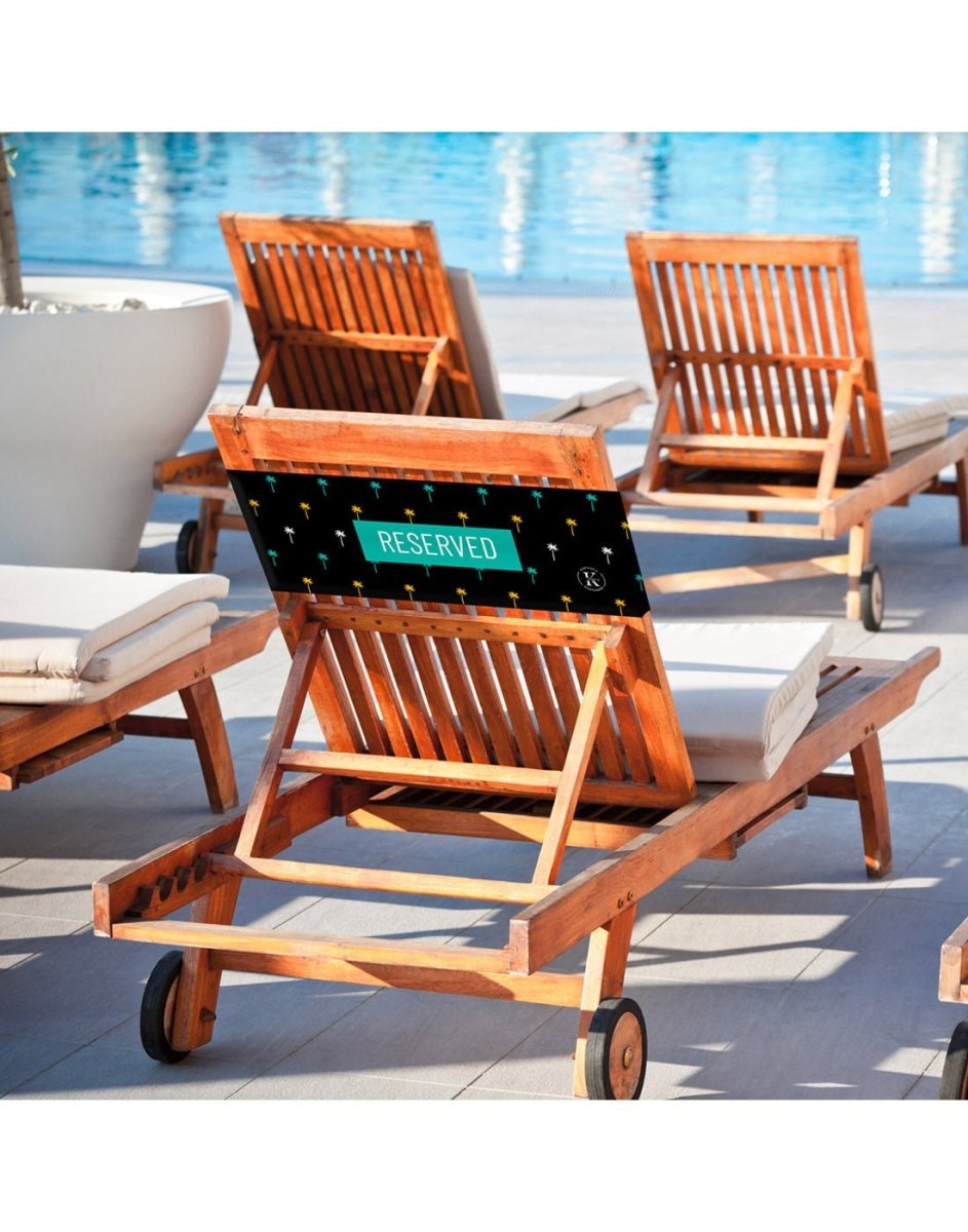 Lifestyle image of palm tree K5 Reserved Chair Sleeve, placed on a poolside chair.