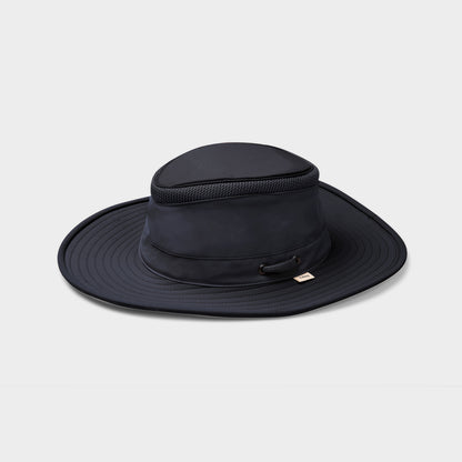 The Tilley LTM6 Airflo® Hat by Tilley is a navy blue, recycled nylon wide-brim hat with mesh, shown on white.