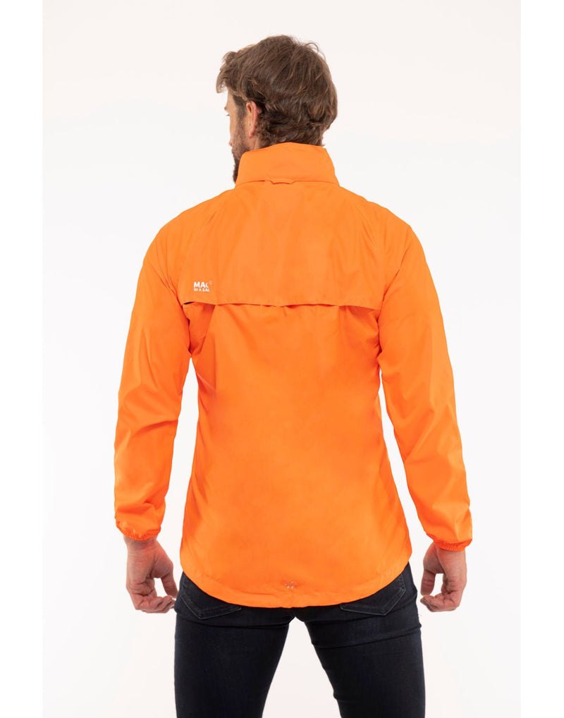 Man wearing Mac in a Sac Origin II Neon Packable Waterproof Jacket in neon orange, back view.