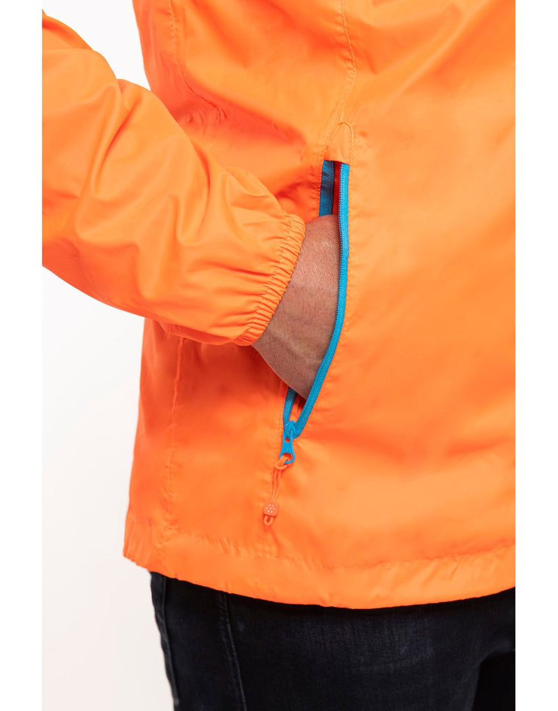 Close up of hands in pocket of neon orange Mac in a Sac Origin II Neon Packable Waterproof Jacket.