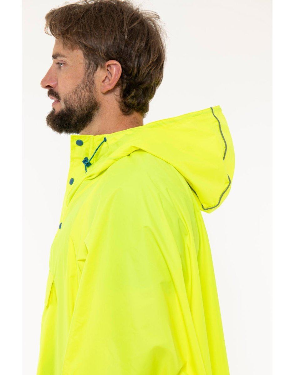 Man wearing Mac in a Sac Packable Waterproof Poncho in neon yellow, close up side view.