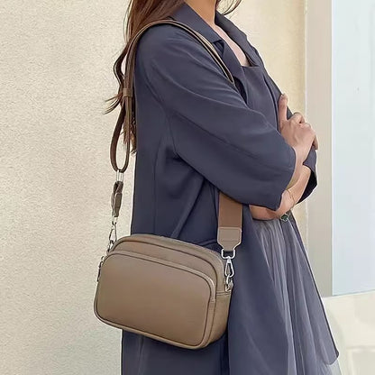 Lifestyle image of woman wearing a blue shirt and the taupe Alina's Front Pocket RFID Crossbody