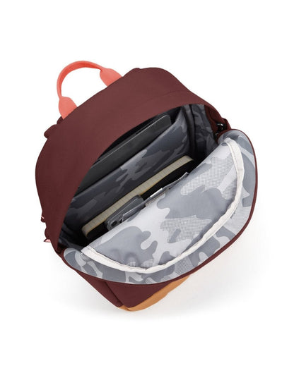 Pacsafe® Go 15L Anti-theft Backpack, garnet red with tan bottom gusset. Bag unzipped showing the interior of the bag.