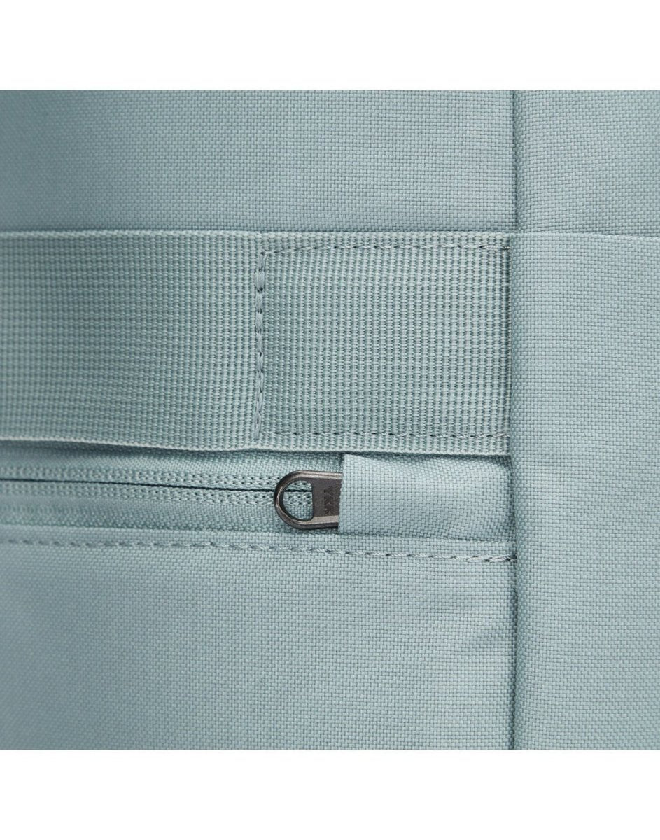 Close up of back zipper pull on fresh mint backpack, tucked into safety slot