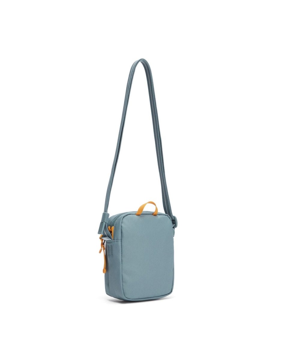 Pacsafe® GO Anti-Theft Micro Crossbody in mint green colour, back view with cut-resistant strap extended.