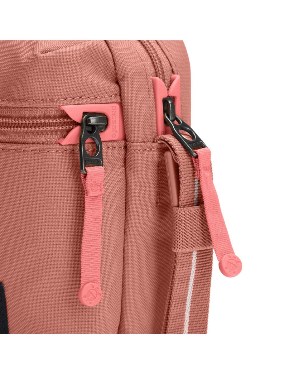 Pacsafe® GO Anti-Theft Micro Crossbody in rose colour, close-up of two zippers with dock locks.