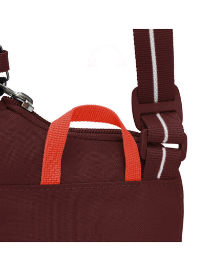 Close up of bright red top grab handle on garnet red bag