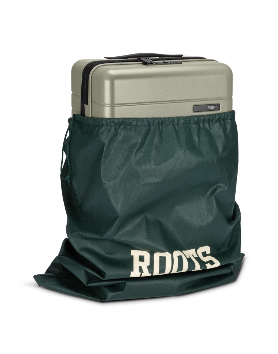 Front angle view of Roots Travel 19" Hardside Spinner Carry-on in sage, placed in a Roots bag.