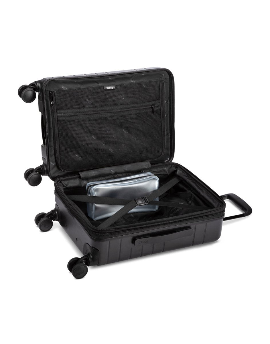 Angled view of unzipped Roots Travel 19" Hardside Spinner Carry-on in black, packed with items.