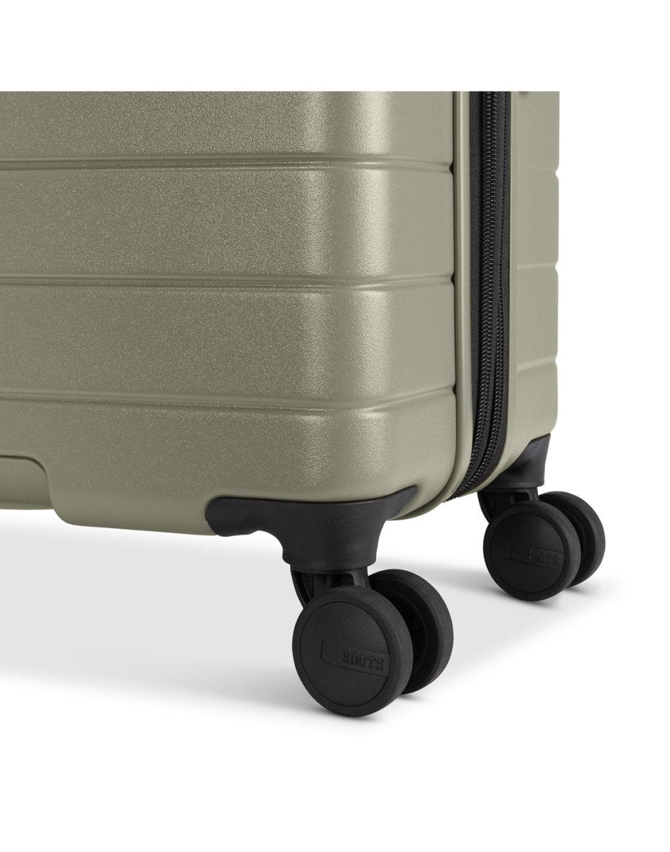 Roots Travel 24" Expandable Hardside Spinner in sage, close-up view of 2 spinner wheels.