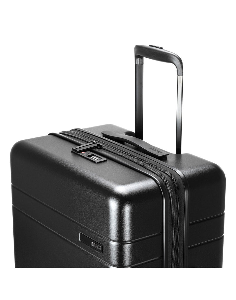 Roots Travel 24" Expandable Hardside Spinner in black, close-up view of extended luggage handle.