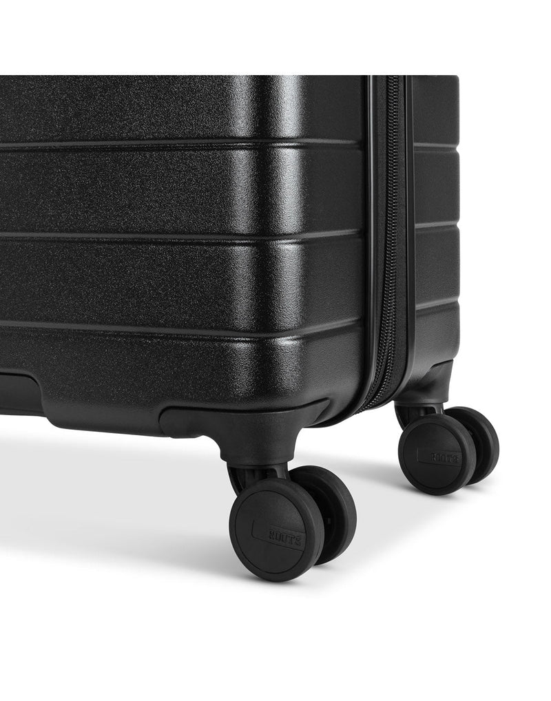 Roots Travel 24" Expandable Hardside Spinner in black, close-up view of 2 spinner wheels.