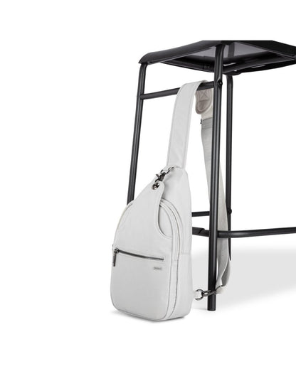 Side angle view of Roots Travel Sling Bag in antarctica, positioned against a stool.