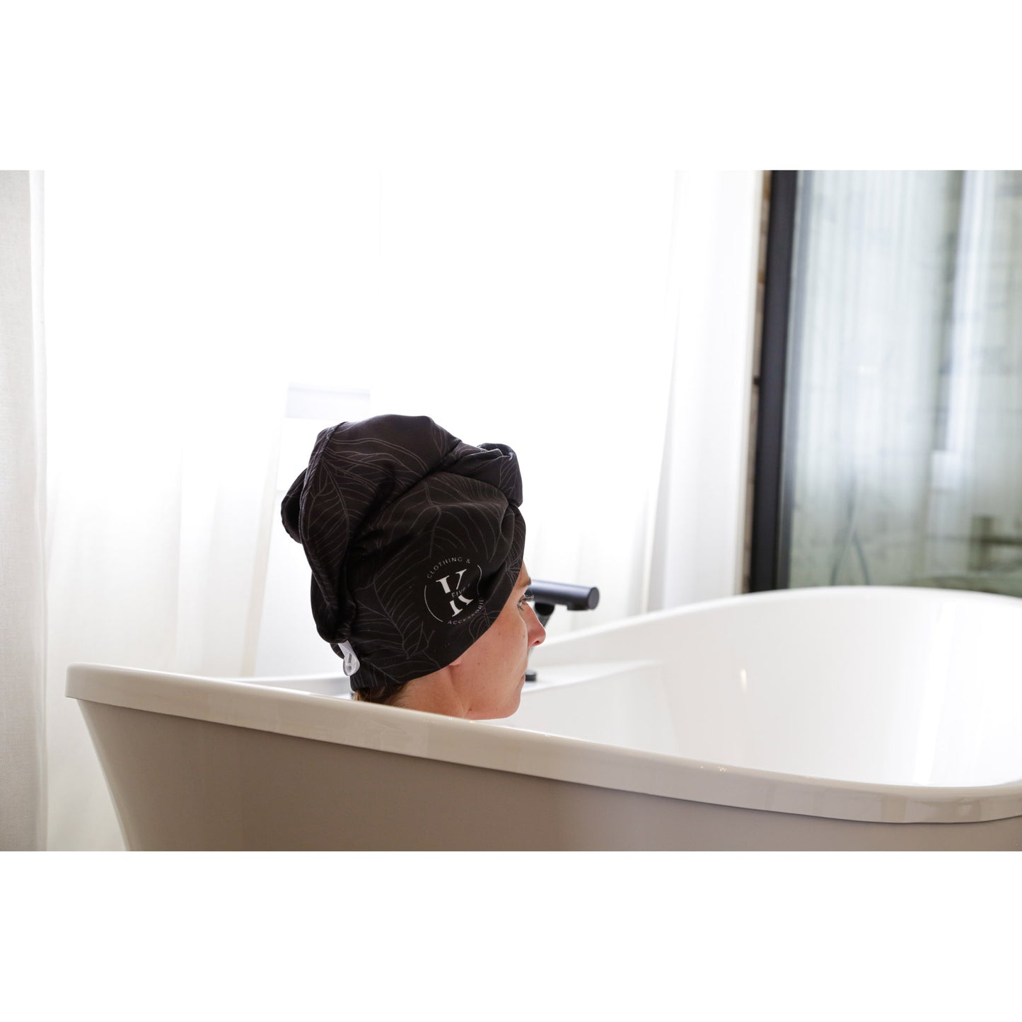 Relaxing in a bright bathroom with the K5 Microfibre Hair Towel absorbing water efficiently.