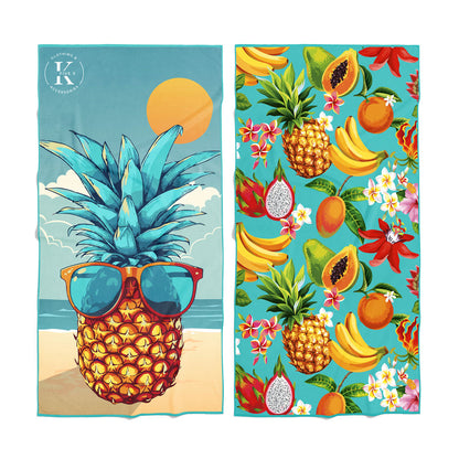 Two K5 Microfibre Beach Towels: one features a pineapple, the other has tropical fruit and flowers.