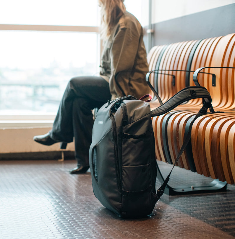 Carry-on backpack sits beside woman