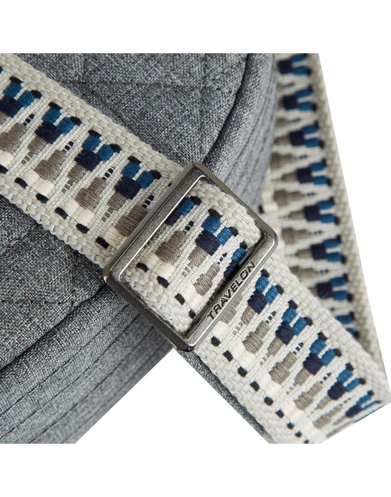 Close up of woven guitar strap style crossbody strap with metal buckle adjuster