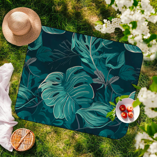 Product Image – A picnic on grass features a tropical leaf blanket, apples, and the K5 XXL Microfibre Beach Towel.