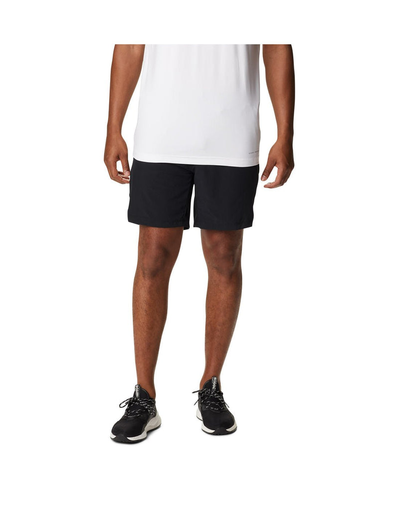Man wearing a white t-shirt, black running shoes, and the Columbia Men's Alpine Chill™ Zero Shorts in black, front view 