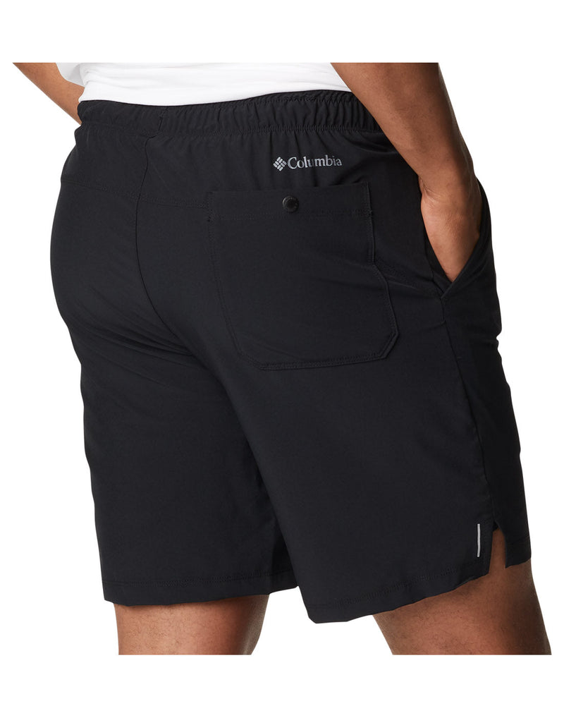 Close up of man wearing a white t-shirt and the Columbia Men's Alpine Chill™ Zero Shorts in black, back view, with hands in pockets