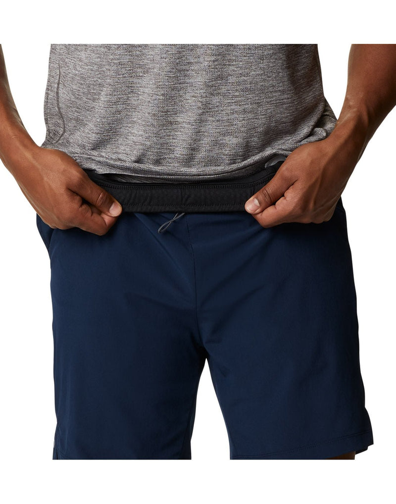 Close up of man wearing a grey t-shirt and the Columbia Men's Alpine Chill™ Zero Shorts in collegiate navy, front view, folding down waistband