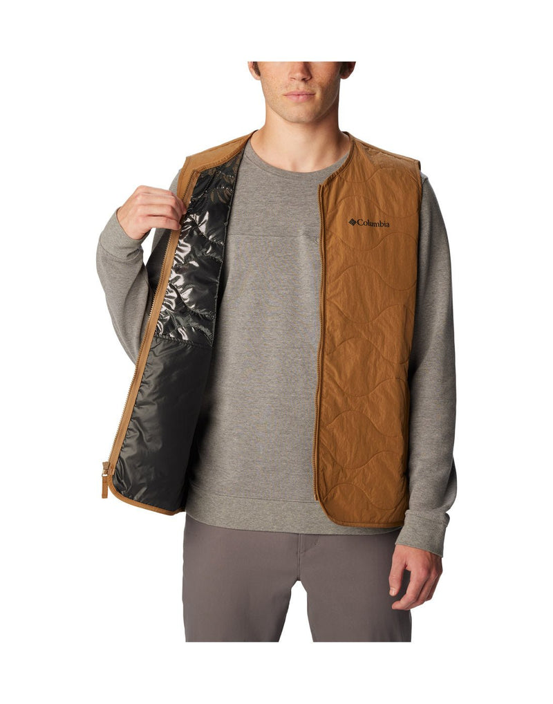 Front view of a man wearing Columbia Men's Birchwood™ Vest in Delta brown colour. Unzipped and showing the thermal reflective lining.