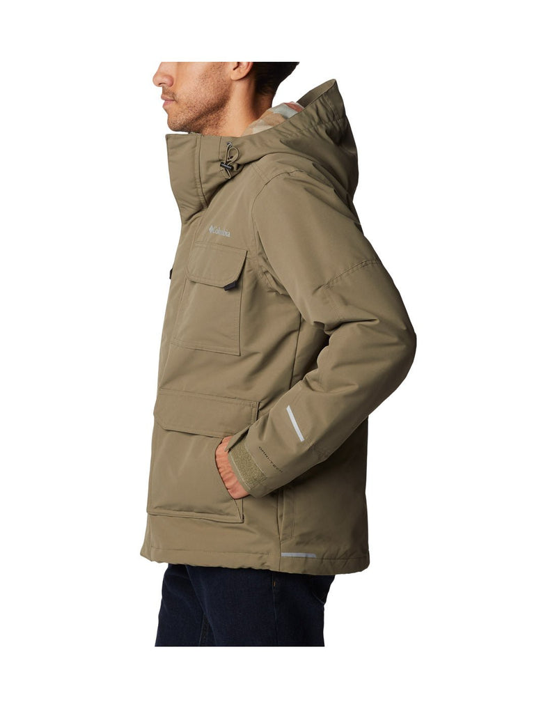 Side view of a man wearing the Columbia Men's Landroamer™ Lined Jacket in Stone Green colour, hood down.