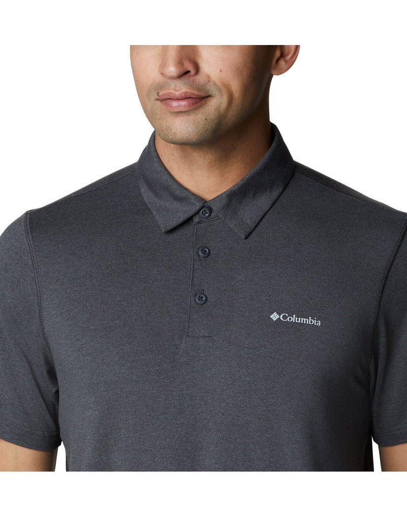 Upper torso view a man wearing Columbia Men's Tech Trail™ Polo Shirt in shark heather colour.  Buttoned up  and with a view of the Columbia logo embossed in white on upper left chest.