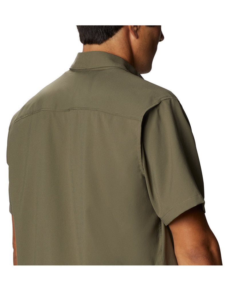 Upper torso back right side view of a man wearing a Columbia Men's Utilizer™ II Solid Short Sleeve Shirt in stone green colour.  Showing the vent in the back of the shoulder sleeve seam.