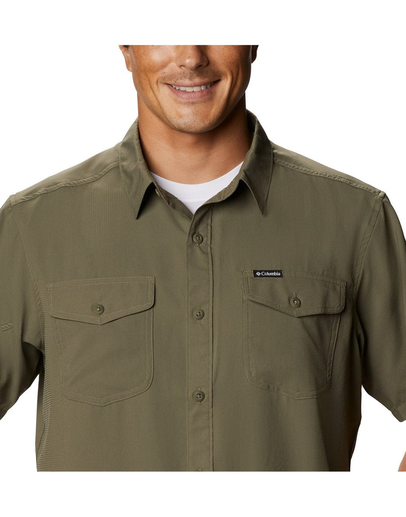 Upper torso view of a man wearing a Columbia Men's Utilizer™ II Solid Short Sleeve Shirt in stone green colour and showing the two multi-functional pockets.