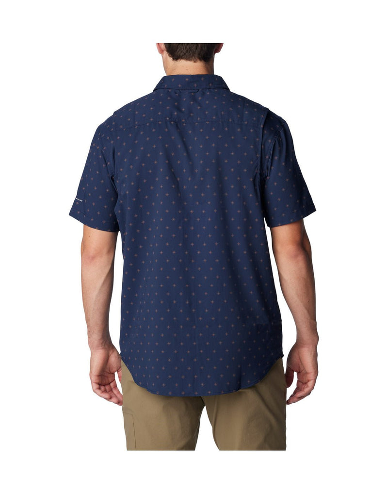 Man wearing khaki pants and Columbia Men's Utilizer™ Printed Woven Short Sleeve Shirt in collegiate navy dawn dot pattern, back view