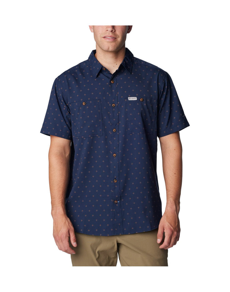 Man wearing khaki pants and Columbia Men's Utilizer™ Printed Woven Short Sleeve Shirt in collegiate navy dawn dot pattern, front view