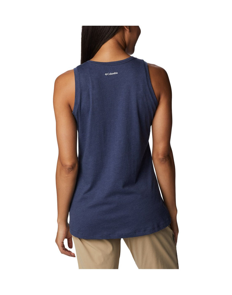 Woman wearing light khaki pants and Columbia Women's Bluff Mesa™ Tank in nocturnal heather, indigo colour, back  view with small white Columbia logo on top center