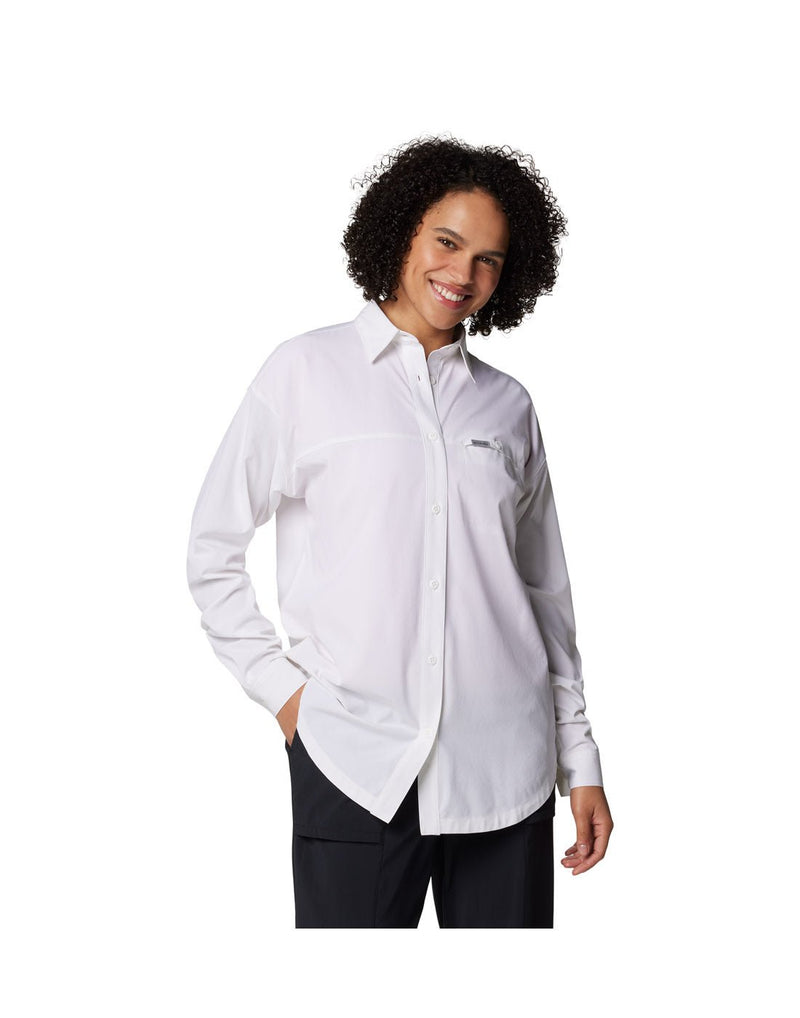 Woman wearing black pants and Columbia Women's Boundless Trek™ Layering Long Sleeve Shirt in white, front view with one hand in pants pocket
