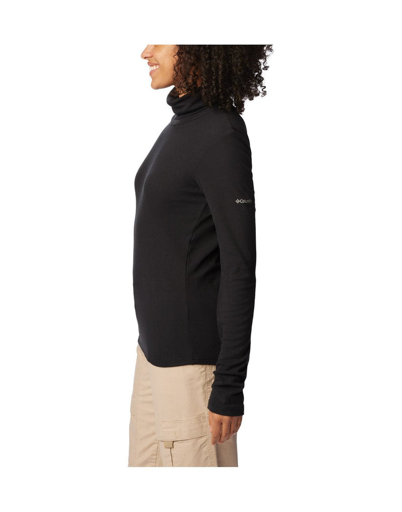 Left side view of a woman wearing the Columbia Women's Boundless Trek™ Ribbed Turtleneck Long Sleeve Shirt in black.