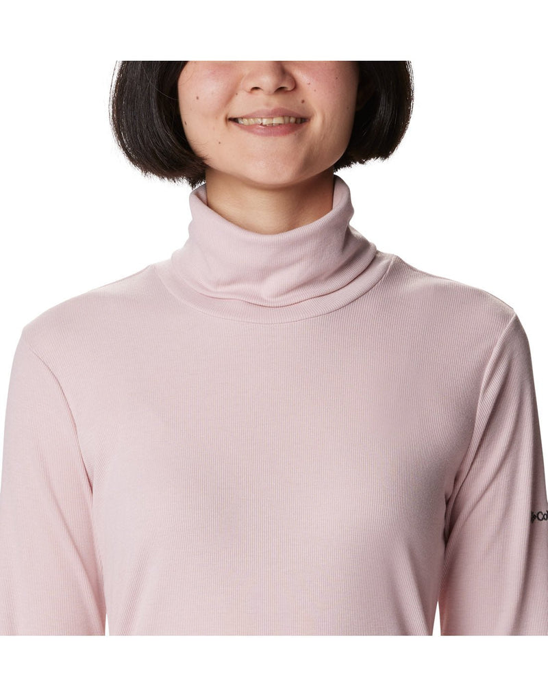 Close-up front view of a woman wearing the Columbia Women's Boundless Trek™ Ribbed Turtleneck Long Sleeve Shirt in Dusty Pink.