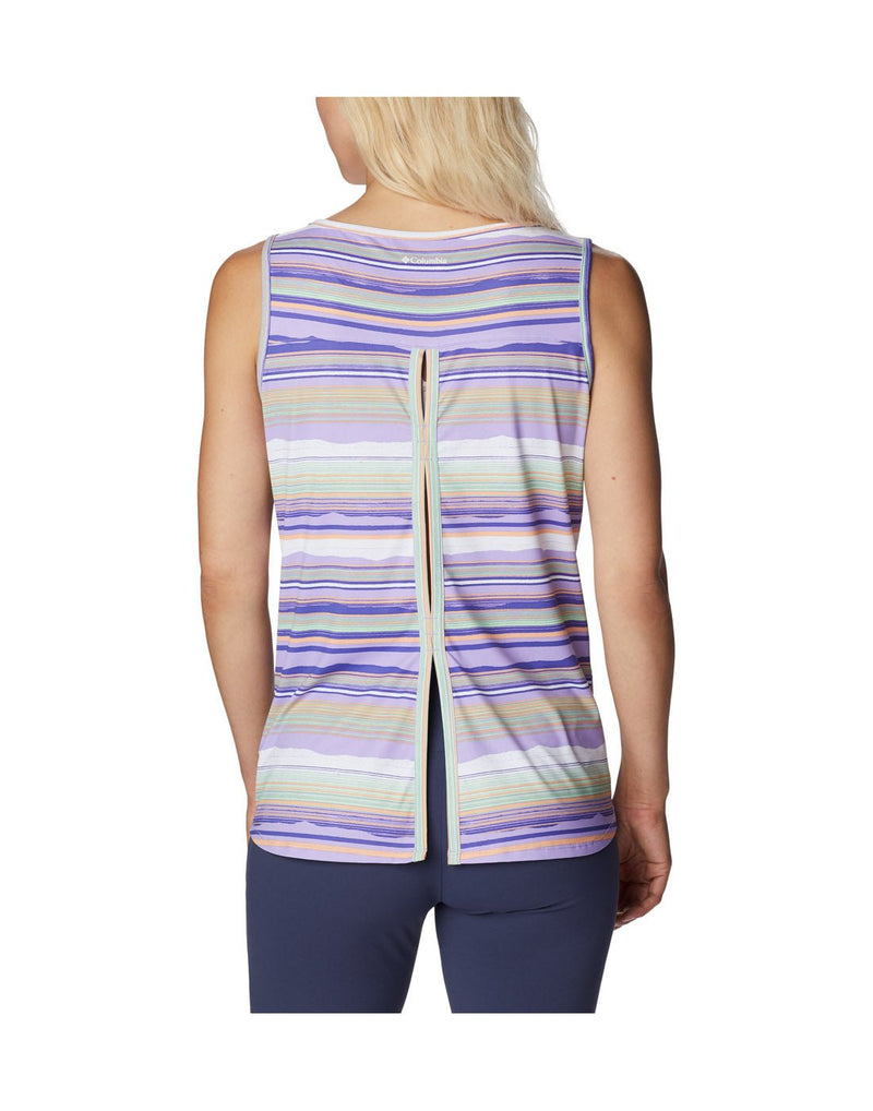Woman wearing indigo colour pants and Columbia Women's Chill River™ Tank in purple, white and pink stripes, back view with pleated slit down back