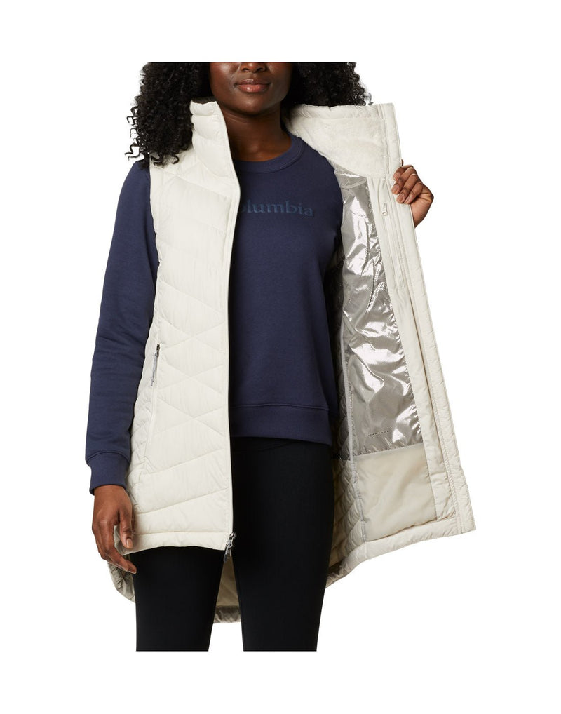 Front view of a woman wearing a Columbia Women's Heavenly™ Long Vest in Chalk colour.  A front panel open to show thermal-reflective lining.