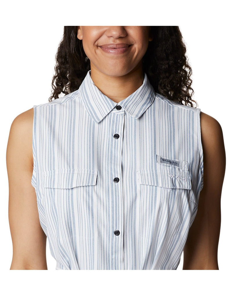 Close up of top half of woman wearing Columbia Women's PFG Sun Drifter™ Woven Dress II in carbon vertical stripe with Columbia logo on left chest pocket