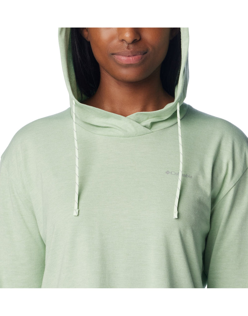 Close up view of a woman wearing Columbia Women's Sun Trek™ Hooded Pullover in Sage Leaf Heather colour with hood up.