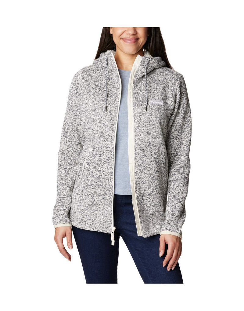 Front view view of a woman wearing the Columbia Women's Sweater Weather™ Sherpa Full Zip Hooded Jacket in Chalk Heather colour, hood down, unzipped.