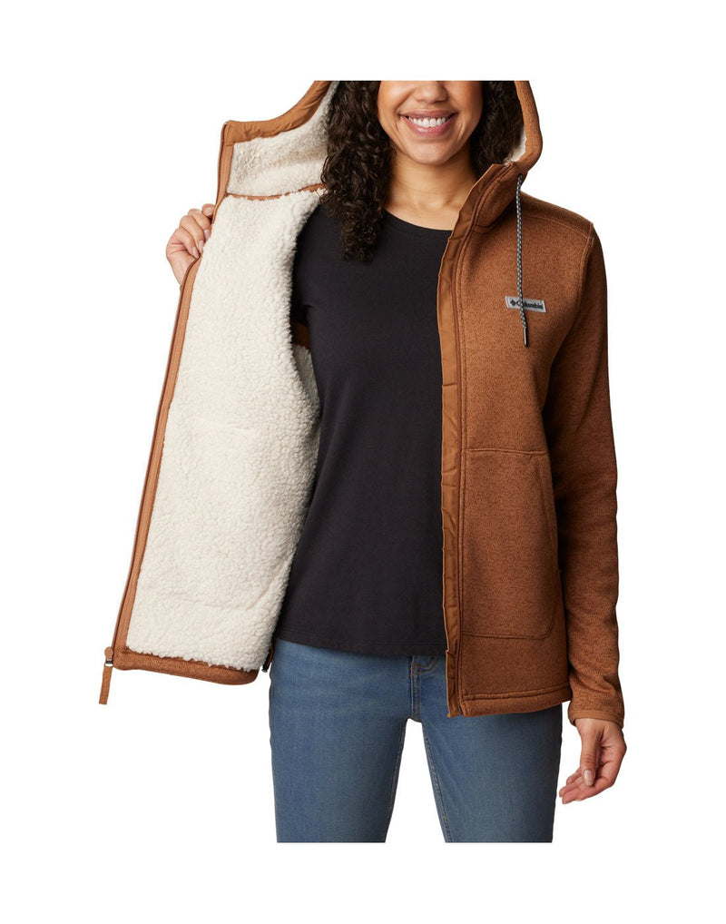Front view of a woman wearing the Columbia Women's Sweater Weather™ Sherpa Full Zip Hooded Jacket in Camel Brown Heather colour, hood up. Unzipped with front panel open showing the interior Sherpa lining.