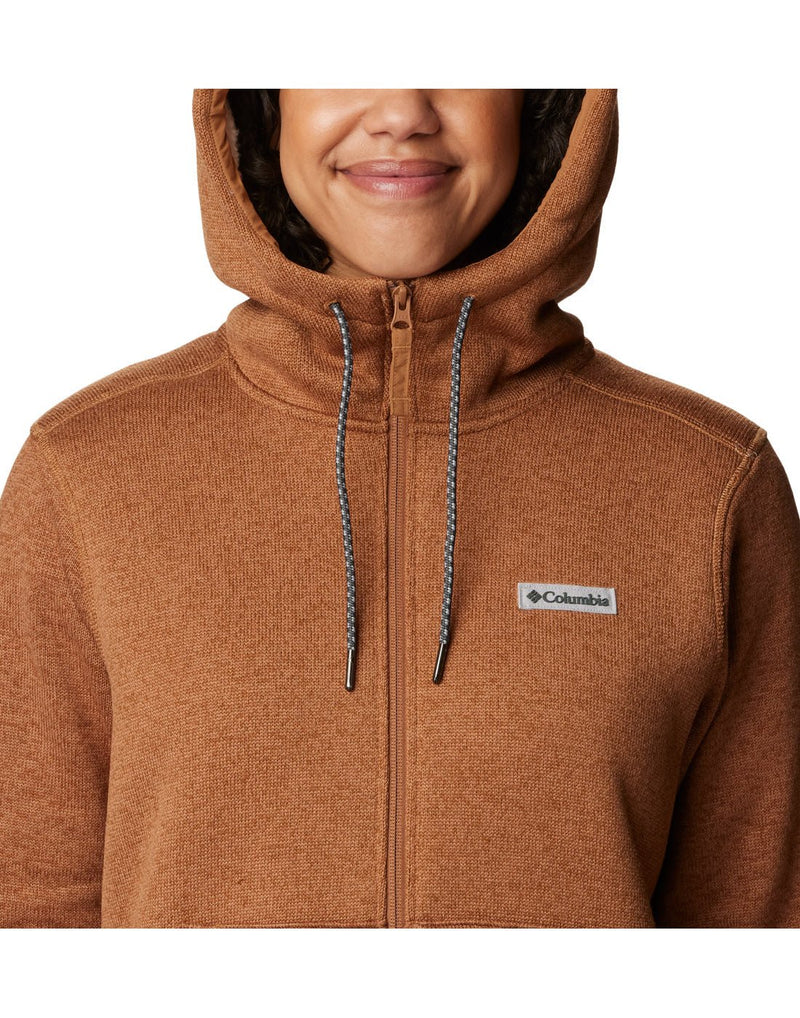 Close-up front view of a woman wearing the Columbia Women's Sweater Weather™ Sherpa Full Zip Hooded Jacket in Camel Brown Heather colour, hood up.