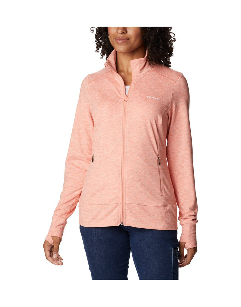 Woman wearing blue jeans and Columbia Women's Weekend Adventure™ Full Zip Jacket in peach heather, zipped up, front view