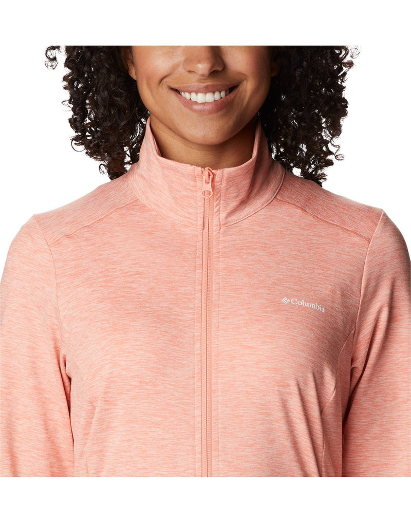 Close up of chest and neckline of Columbia Women's Weekend Adventure™ Full Zip Jacket in peach heather, zipped up, with small white Columbia logo on left chest